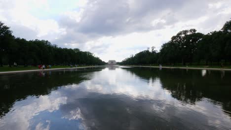 view from the water to the front steps of the lincoln memorial taken from the reflection pond with people in the foreground