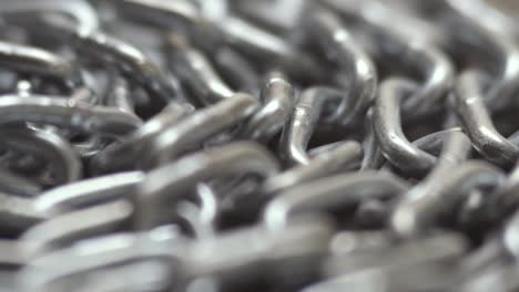 the metal chain slowly rotate. chain links move. industrial background. close up