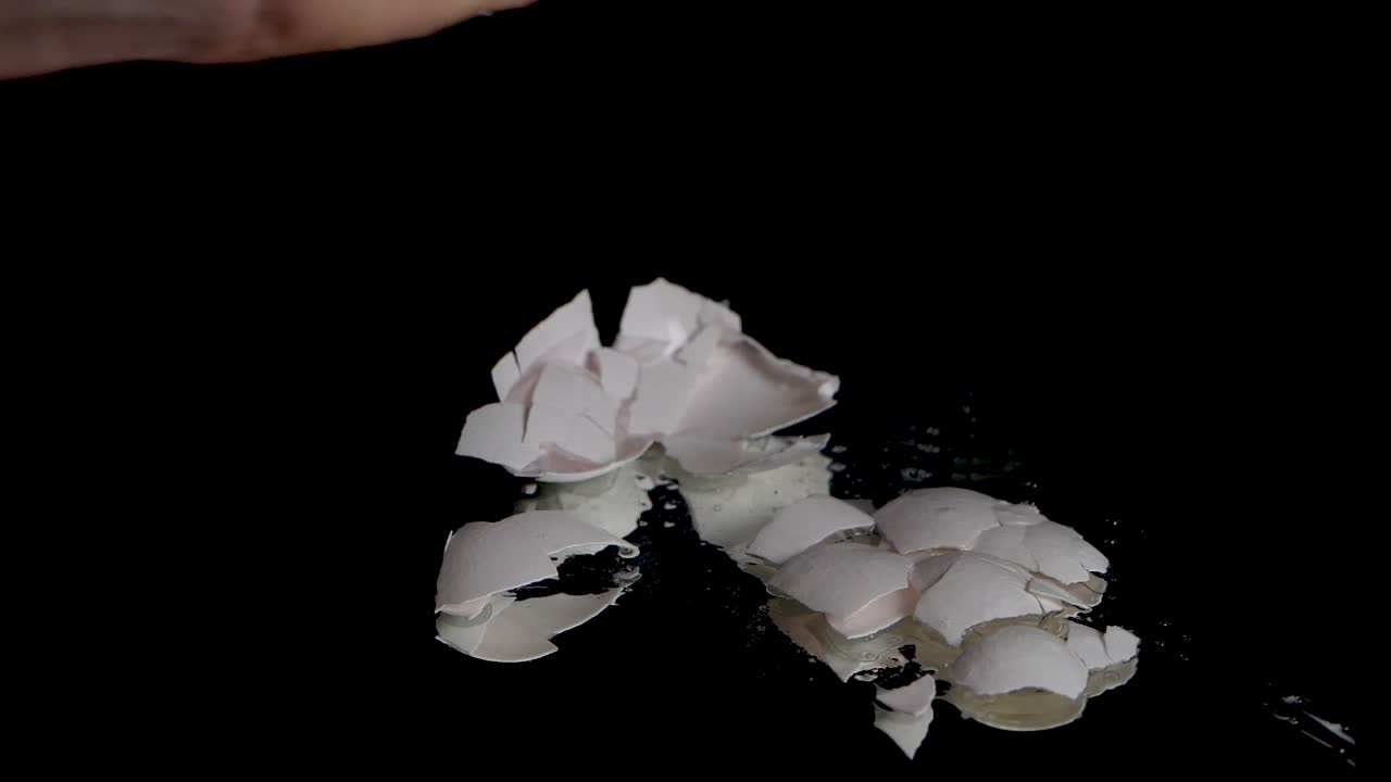 Slow motion shot of smashing a egg shell with a bare hand