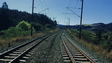 forward moving drone footage of train rail tracks in a rural area of south africa