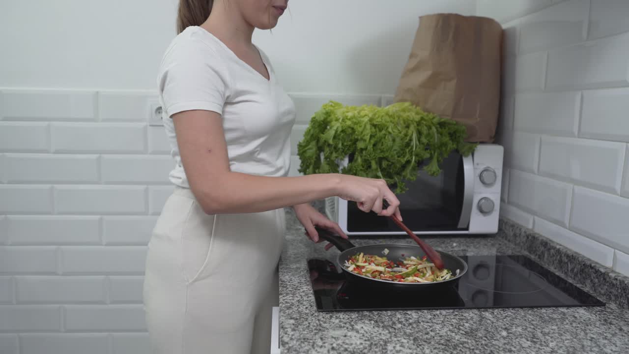 mujer cocinando verduras en una cocina