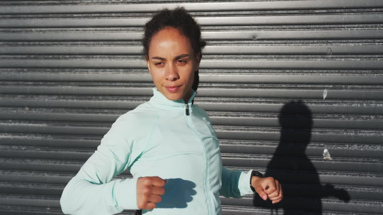 African american woman in sportswear stretching in street before exercising