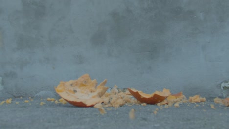 halloween pumpkin is smashed into pieces in slow motion after being dropped onto ground