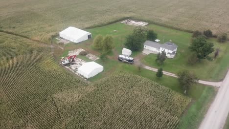 Drone-flyover-of-a-farmyard-and-mature-corn-field-in-early-autumn-in-rural-Iowa