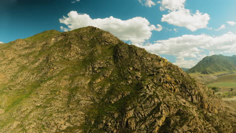 steep rocky mountain peak at glowing sunlight aerial view. wonderful wild scenery with old cliffy ridge performing power of nature. undiscovered lands