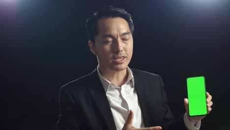 businessman presenting on a green screen smartphone