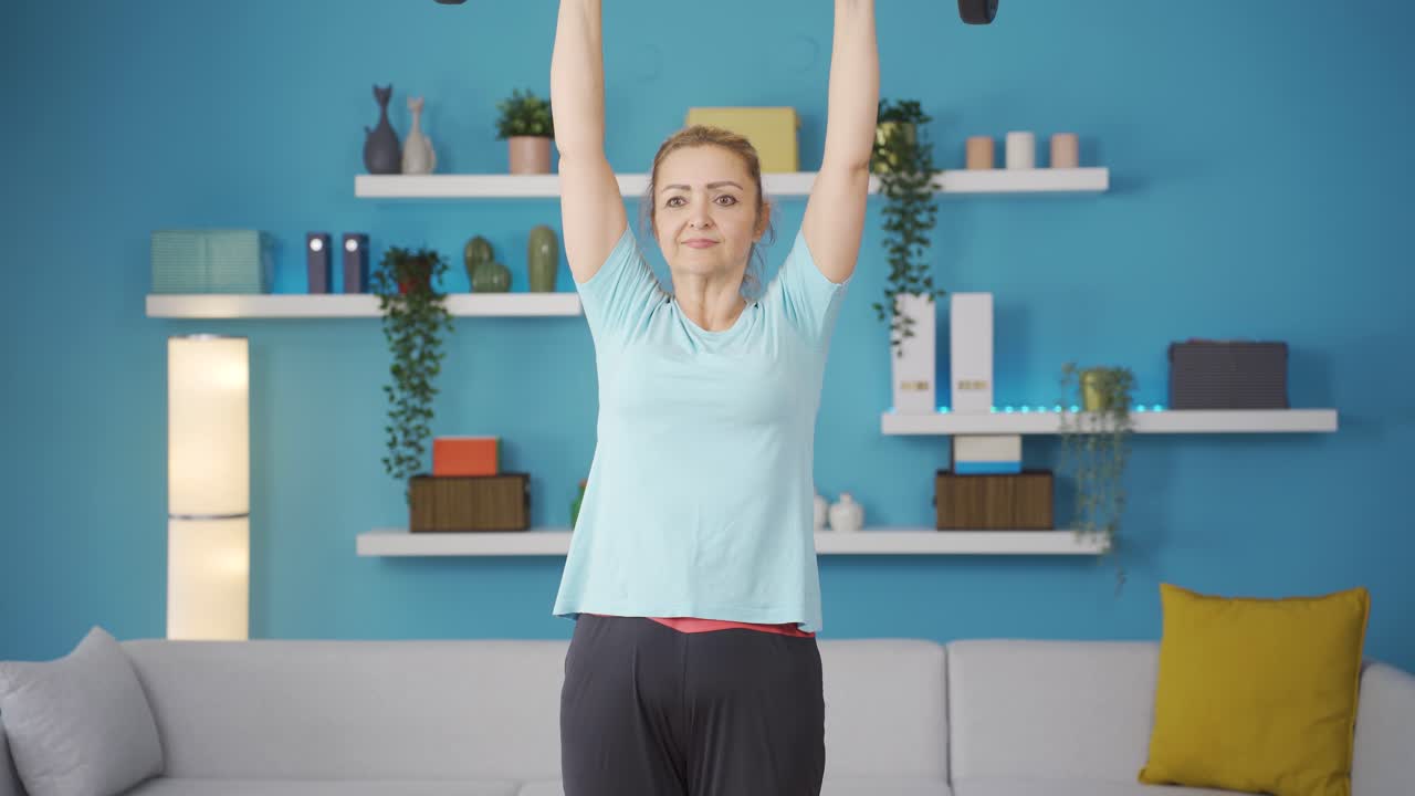 mujer desarrollando los músculos de los hombros con pesas.