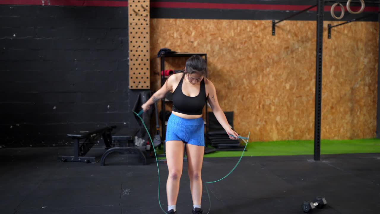 Woman working out with jump rope at the gym