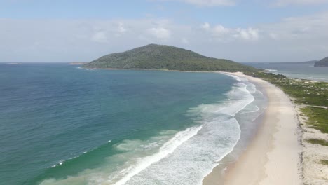promontorio y península del monte yacaaba desde la playa de waynderrabah - olas oceánicas desde la bahía de providencia en nido de halcones, nsw, australia