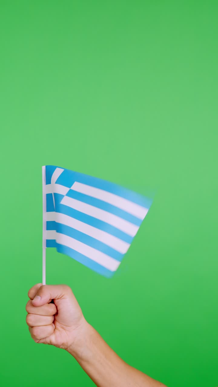 Hand lifting a greek pennant while waving by the wind