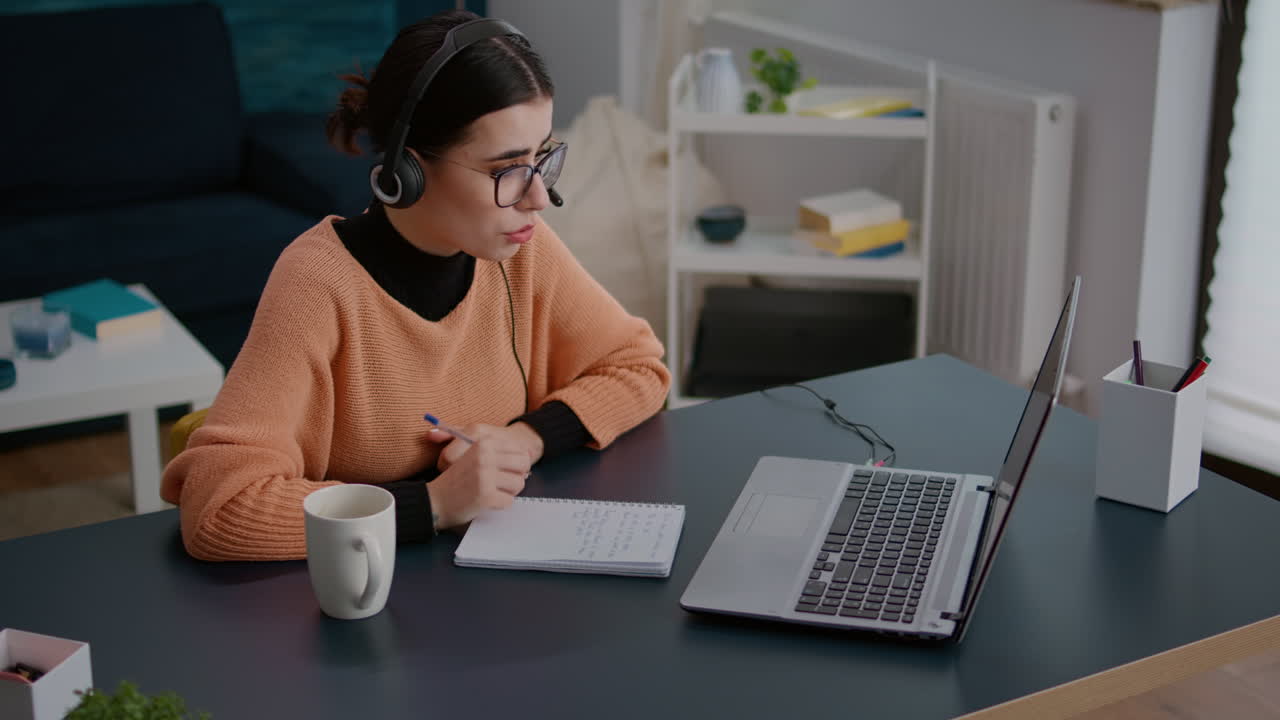 Woman using headphones on remote video call with teacher