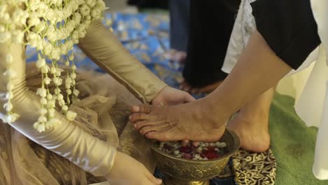 the bride washes and wipes her mother's feet