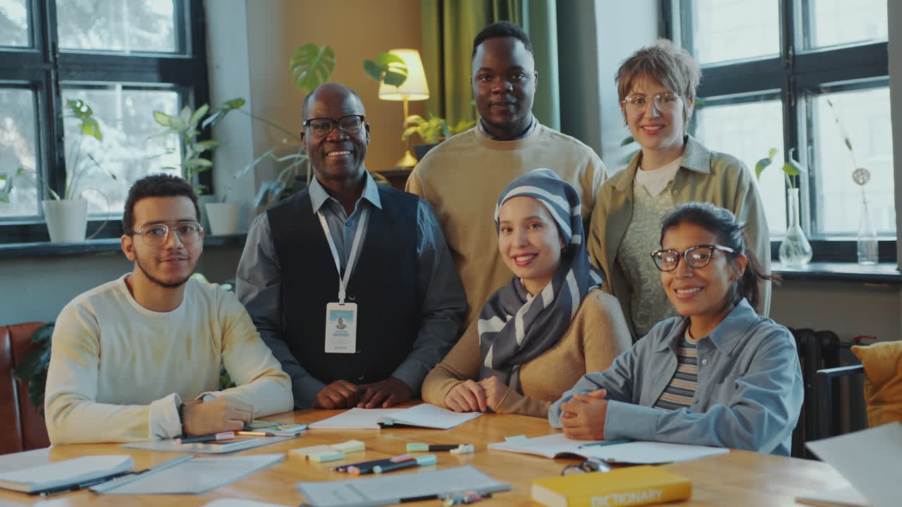 Group Portrait of Cheerful Immigrant Students and Senior Teacher in Classroom