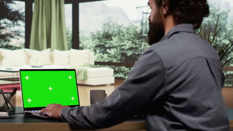 hombre de negocios mira la plantilla de pantalla verde en la pc