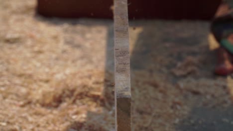 the carpenter is smoothing wood with a planer machine