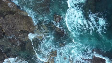 vista aérea de drones de las olas que se estrellan en la costa rocosa