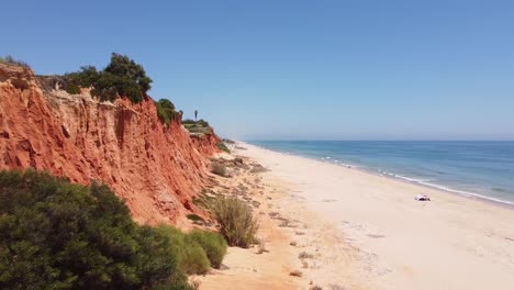 Praia-Vale-do-Lobo-Beach-at-Almancil,-Algarve,-South-Portugal---Aerial-Drone-View-of-the-Red-Cliffs-and-Long-Sandy-Beach