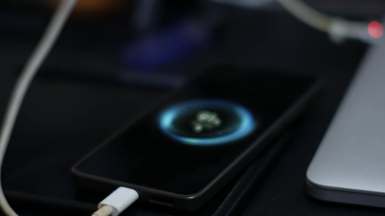 Smartphone Charging Beside Laptop on Modern Work Desk