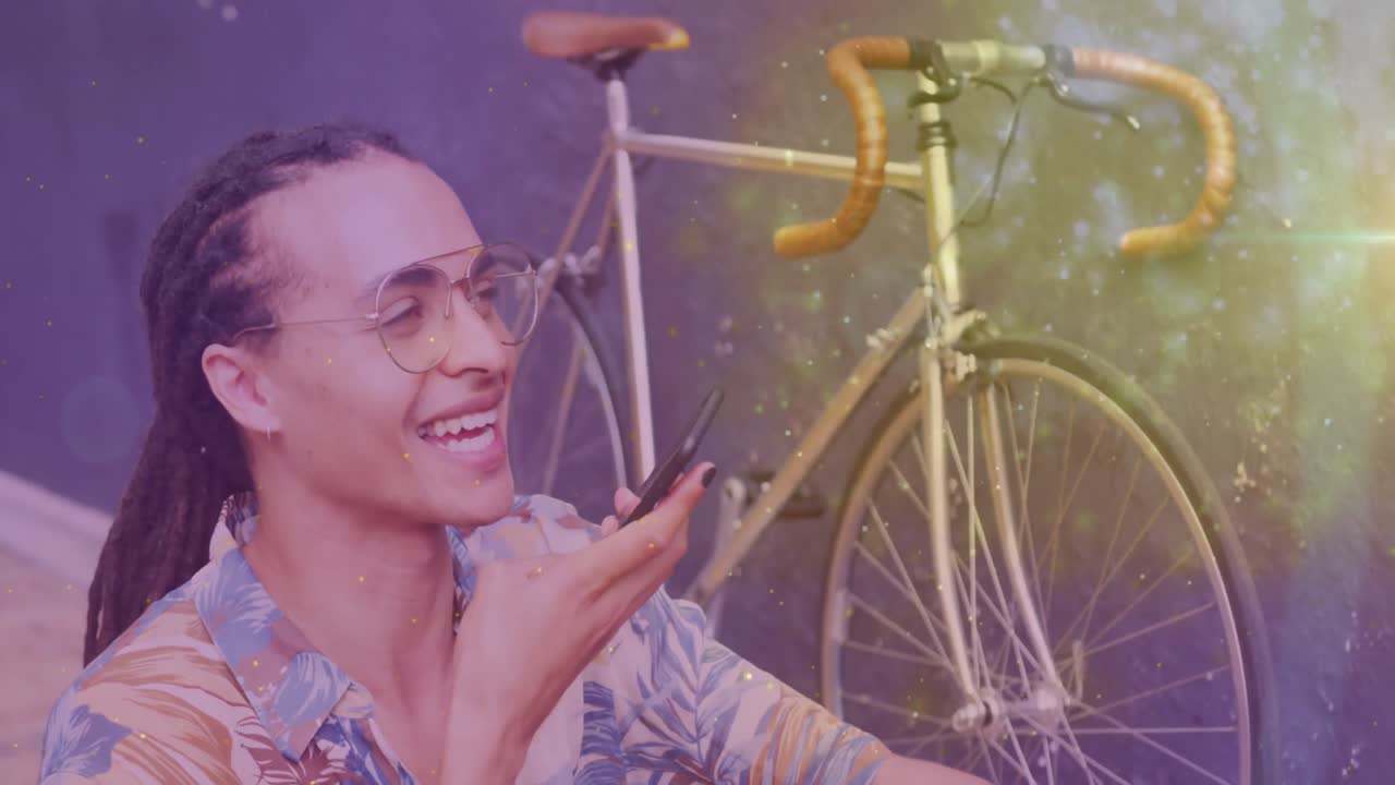 animación de puntos de luz sobre un hombre biracial feliz usando un teléfono inteligente