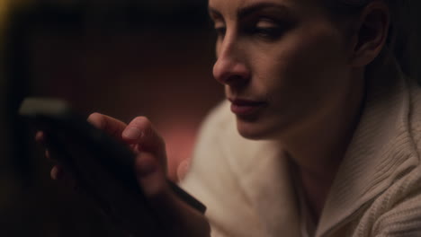 portrait of woman shopping online on smartphone at night