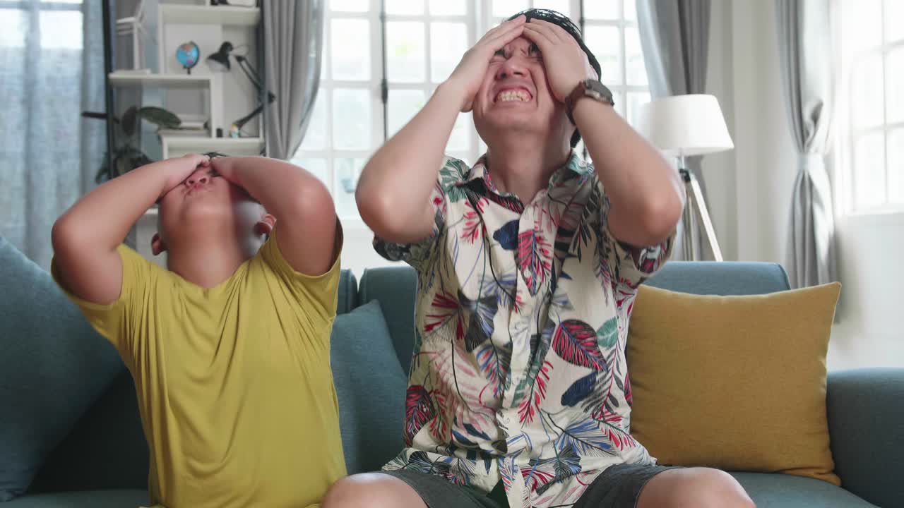 Frustrated Disappointed Asian Father And His Son Are Watching Tv