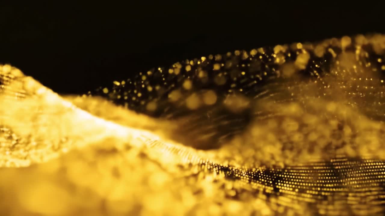 Golden particles swirl and flow in captivating patterns, showcasing their dynamic motion.