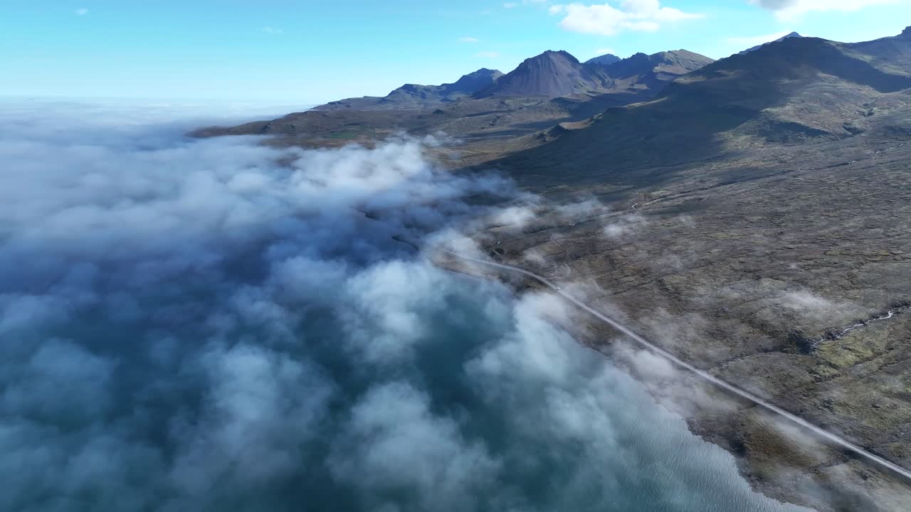 nubes bajas en el fiordo faskrudsfjordur en el este de islandia - toma aérea de drones