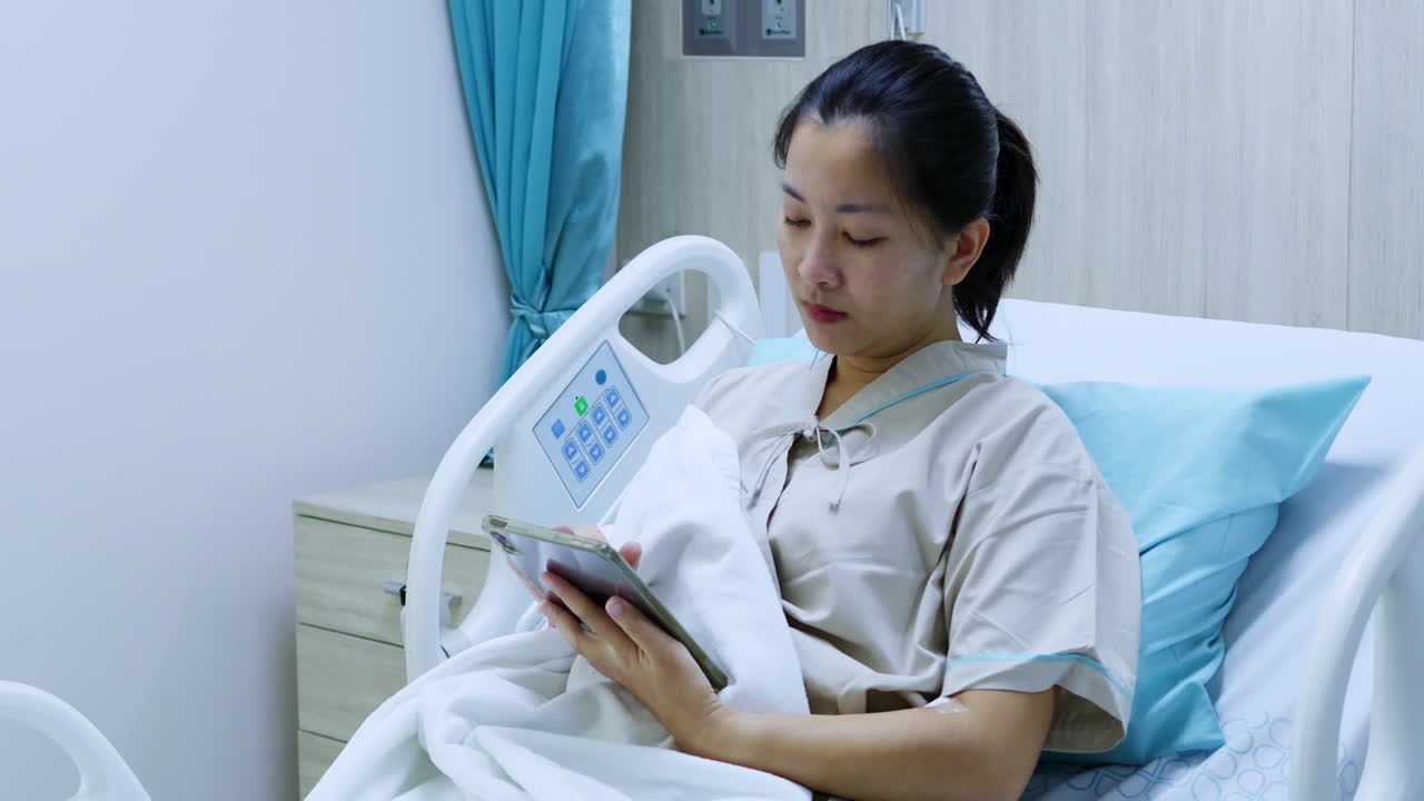 A patient interacts with a digital device in a hospital room highlighting modern healthcare practices