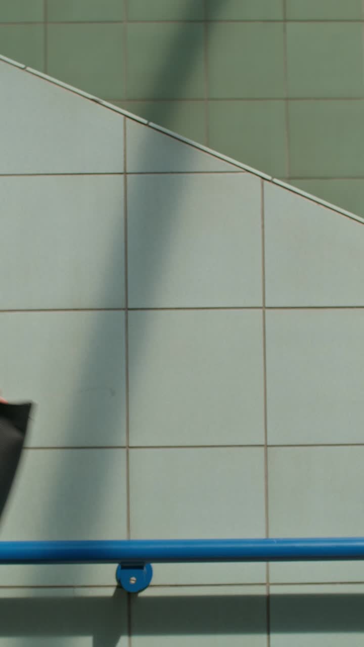 escalera con paredes de azulejos y barandilla azul