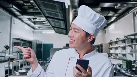 chef usando un teléfono móvil en la cocina de un restaurante