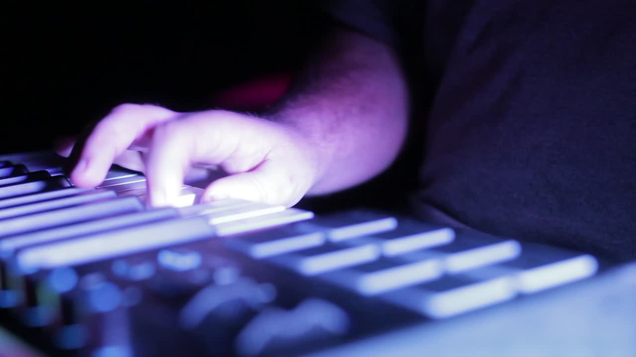 Keyboardist skillfully plays with one hand. DJ playing light show concert.