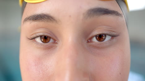 Close-up of swimmer eyes wearing swim cap, focusing before competition