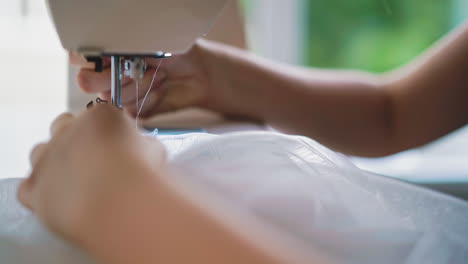costurera cosiendo cortinas suaves con la máquina en el lugar de trabajo