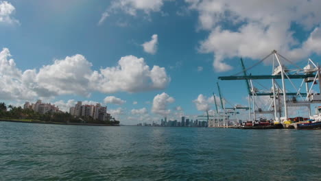 miami harbor by boat with freight and cranes to the starboard and city on the port