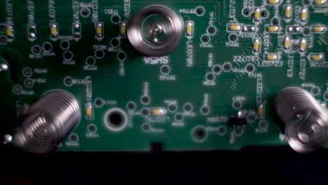 close up shot of an underside of electronic circuit board , pcb plate with springs on green board