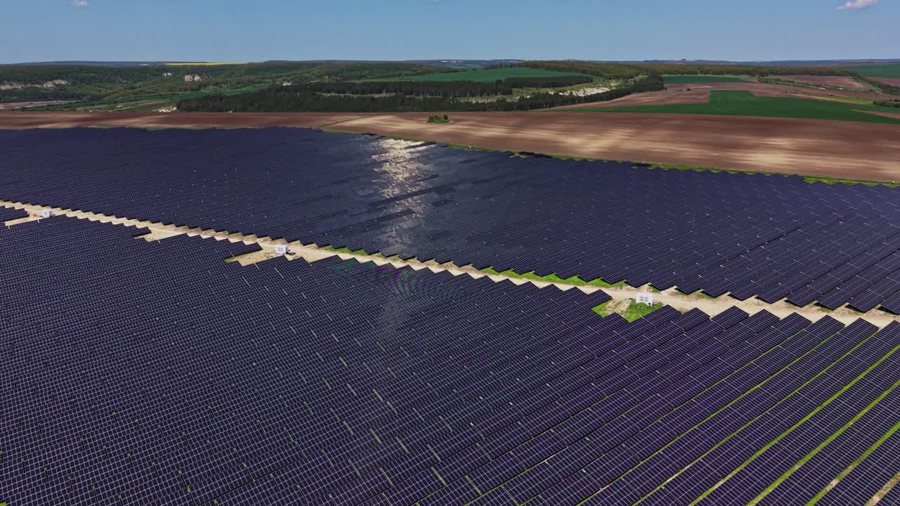 Stort solcelleanlæg i et landligt område med klar, blå himmel