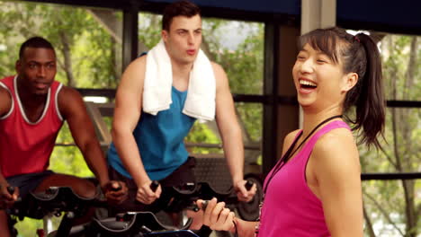 Happy-female-trainer-assisting-men-while-biking