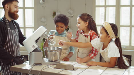 niños probando crema batida en la clase magistral de cocina