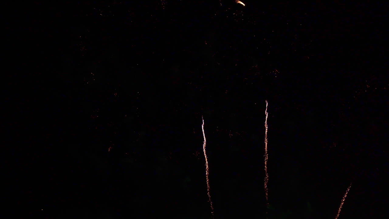 White streaks of fire proceed the firework explosions