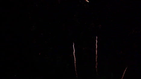 White streaks of fire proceed the firework explosions