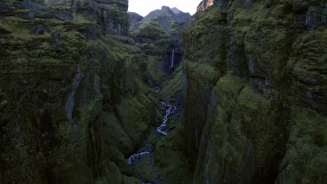 Volando-A-Través-De-Un-Cañón-Majestuoso-En-Islandia-Hacia-Una-Cascada-En-Un-Día-Nublado-De-Otoño