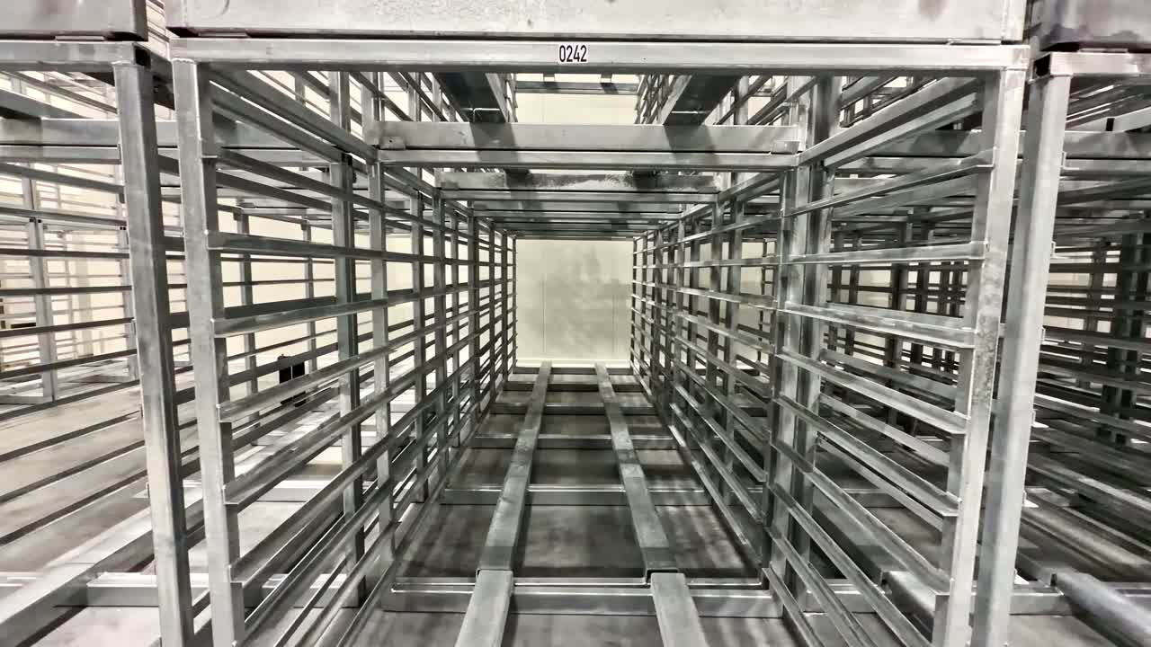 Scaffalature industriali che formano un lungo corridoio all'interno di un luminoso magazzino