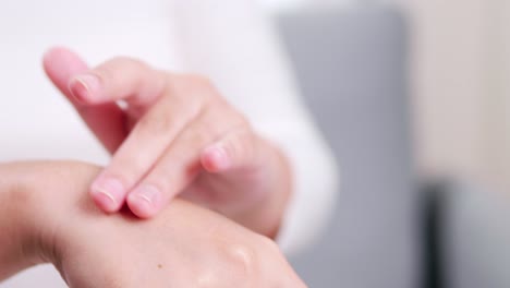 detail of female hands applying moisturizing hand lotion