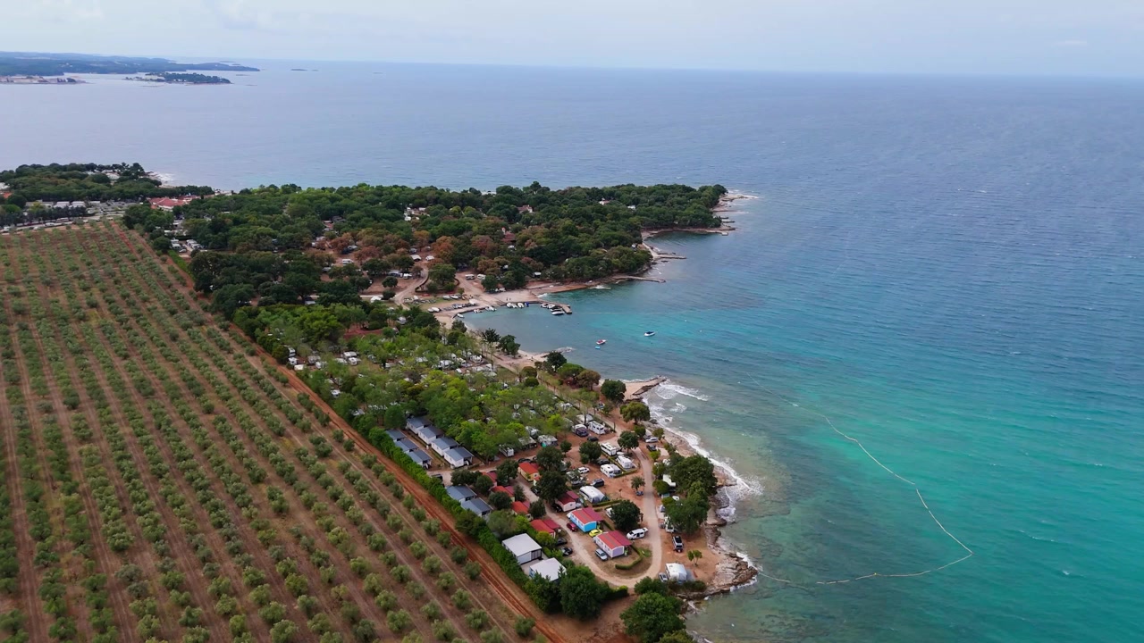FKK Camping Ulika vicino a Parenzo con camper, vista aerea con drone durante una soleggiata giornata estiva sulla splendida costa adriatica in Istria, Croazia.
