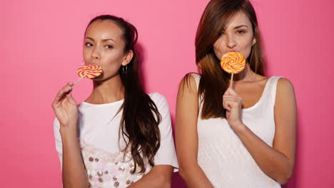 dos mujeres comiendo piruletas