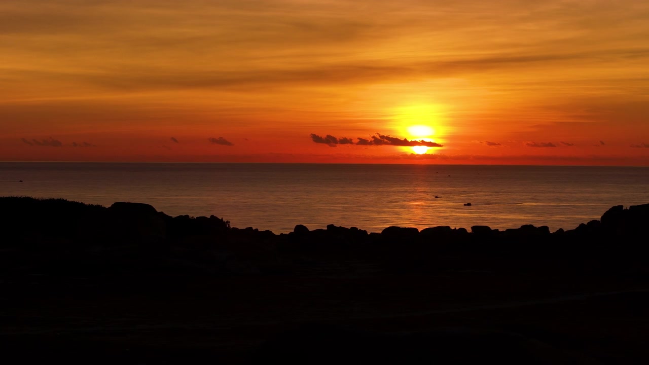 Matahari Terbenam Merah Oranye Cerah di Atas Cakrawala Laut. Dolly Shot Udara Rendah Melakukan Panning Melintasi Taman Batu Pemandangan Indah di Ninh Thuan, Vinh Hai, Vietnam.