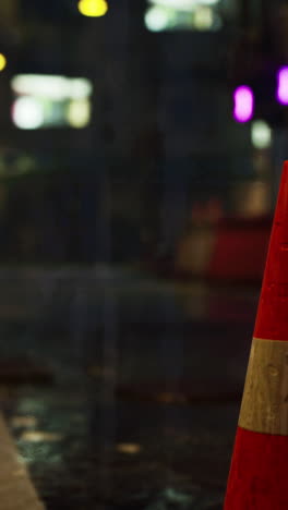 traffic cone on a wet street at night