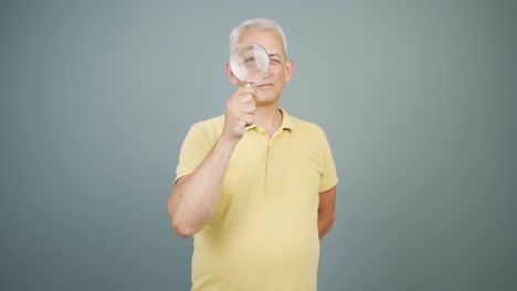 Man-looking-at-camera-with-magnifying-glass.