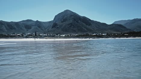 Eine-Lagunenmündung-Mit-Wasser,-Das-Zum-Meer-Fließt,-Und-Bergen-Im-Hintergrund-In-Hermanus,-Südafrika