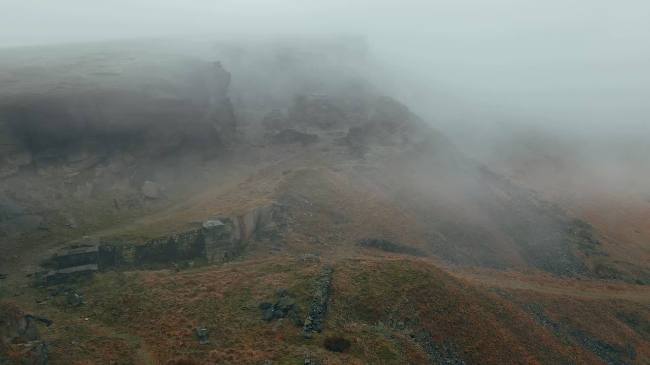 vista aérea por drones de las nubes moviéndose lentamente sobre las colinas peninas, en una mañana nublada, colinas doradas y hermosos acantilados rocosos y páramos